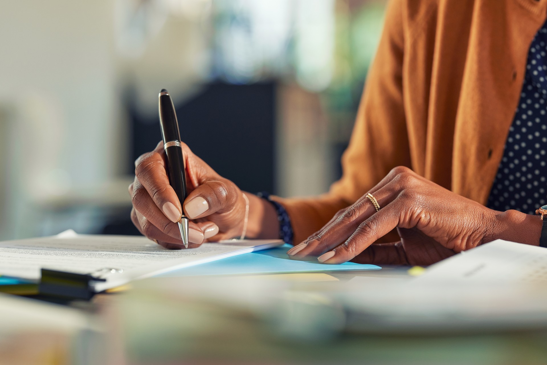 African business woman hand writing on paper at desk